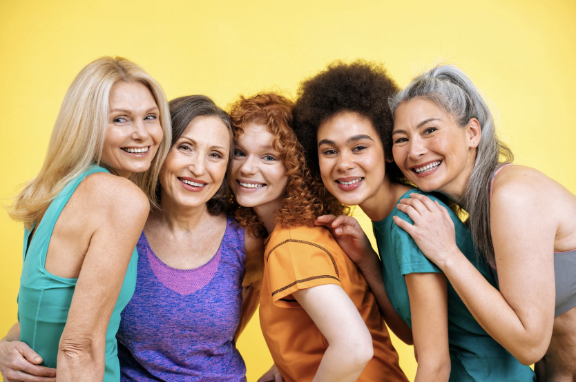 five women of different ages smiling together